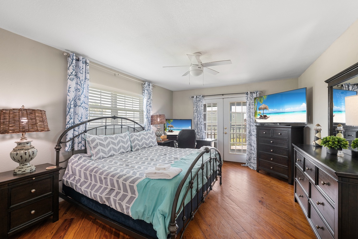 Drift off in your island-inspired bedroom, where a comfy bed, warm wood floors, and tropical touches set the stage for peaceful vacation dreams.