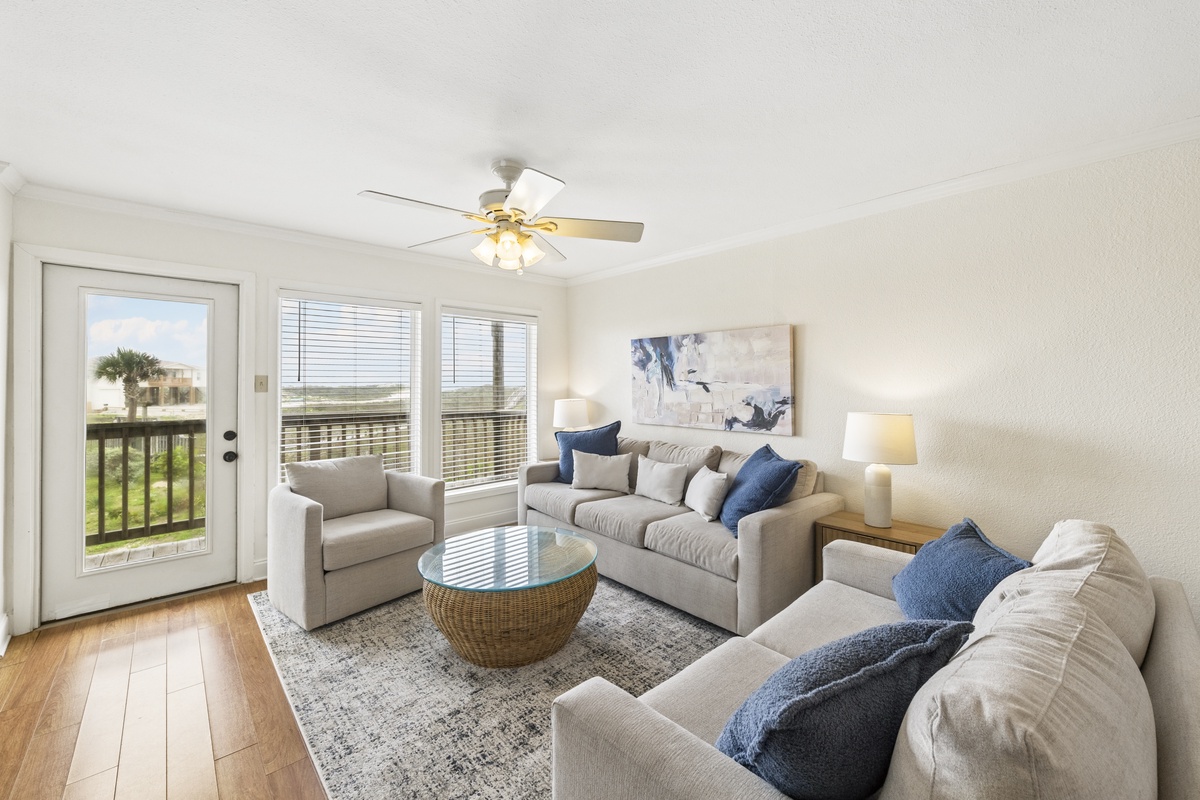 Unwind in your bright, coastal living room where soft sofas and soothing blues invite relaxation. Natural light pours through large windows, and your private balcony door opens to ocean breezes and peaceful views.