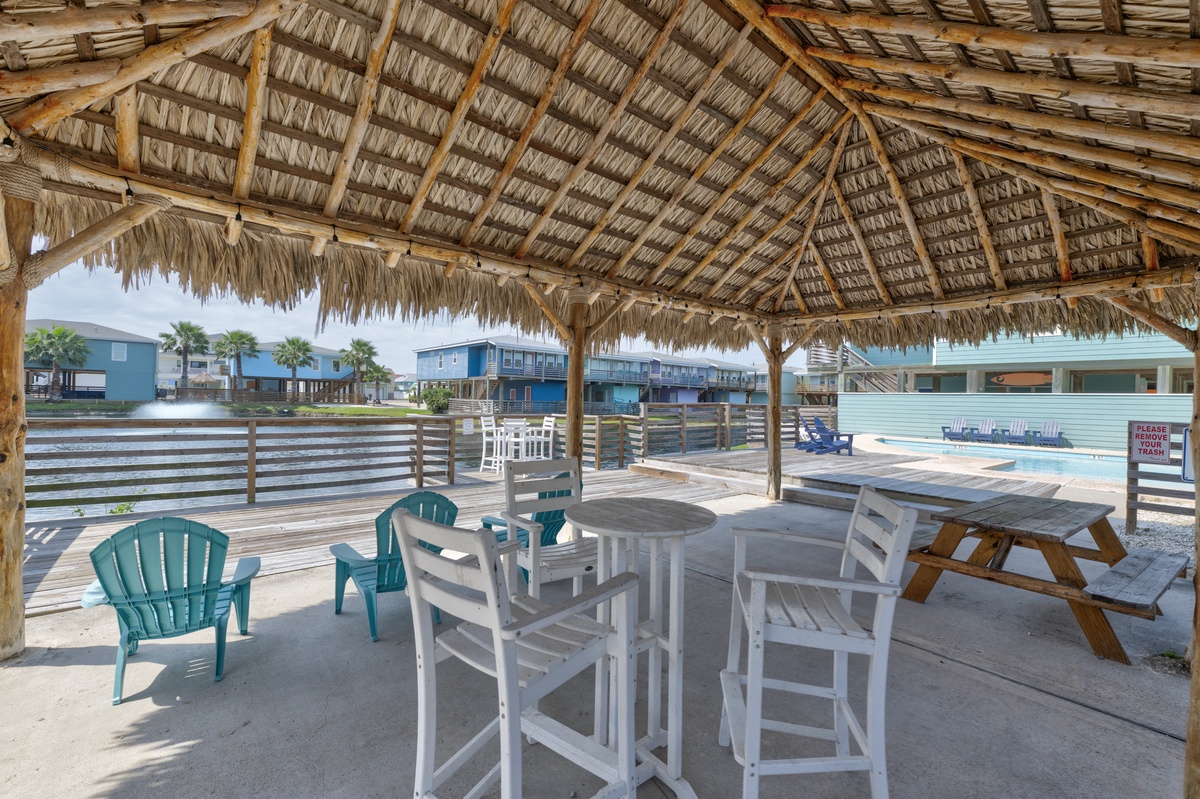 A shaded palapa with plenty of seating overlooks the community pool and neighboring homes—a great spot to relax on warm afternoons.