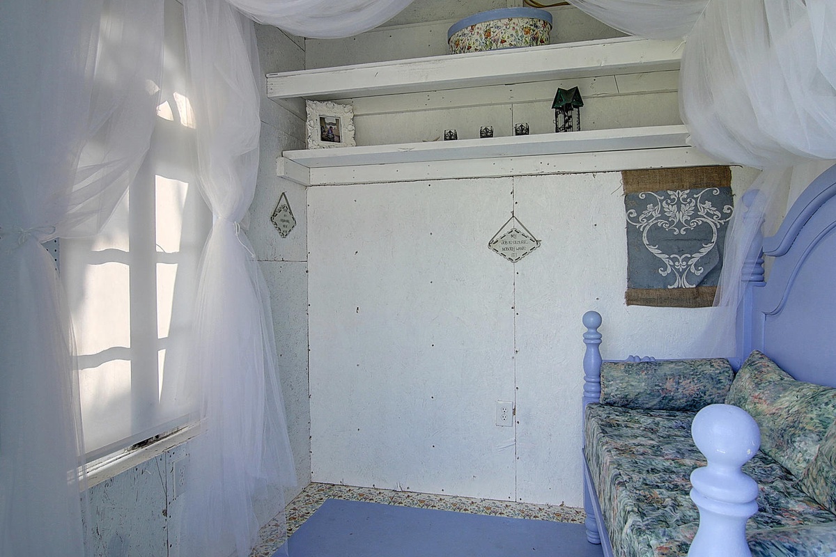 Drift into peaceful dreams in your charming hideaway, where flowing curtains frame your window and built-in shelving holds your treasures.