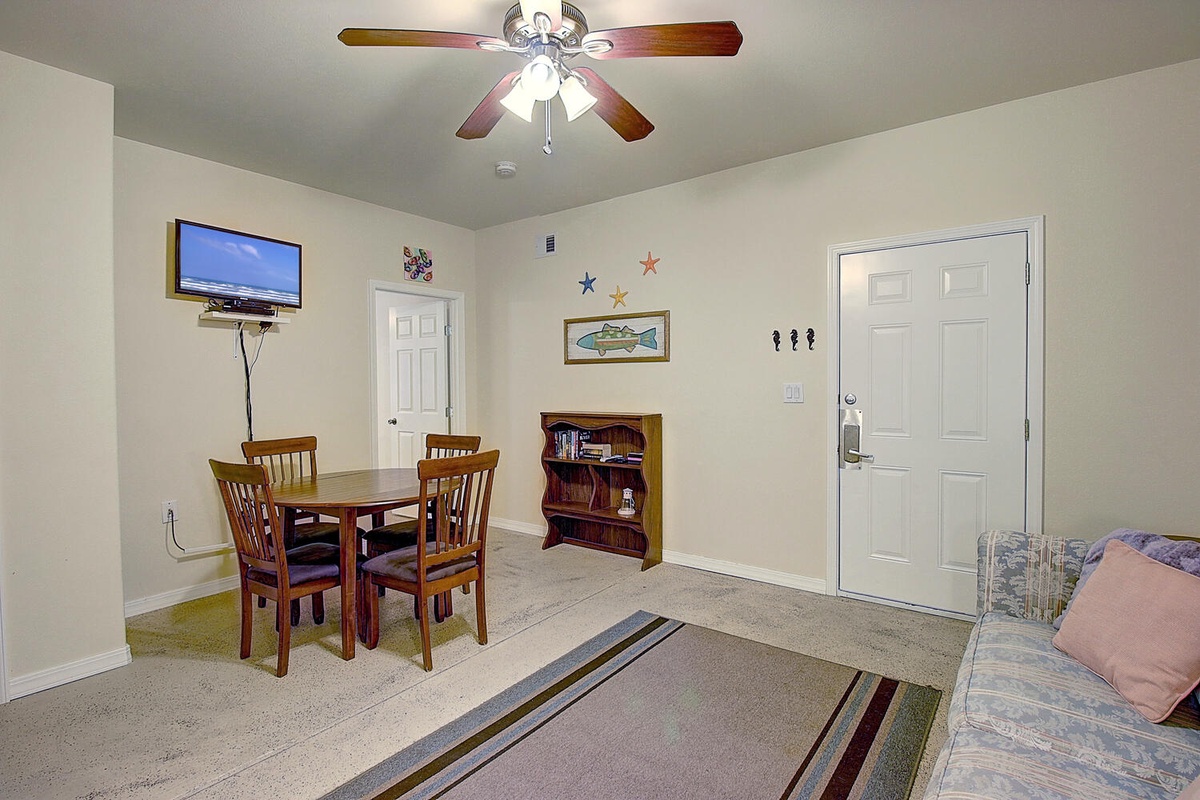 Gather around your cozy dining table for meals and games, with a TV for entertainment and bookshelf for quiet moments together.
