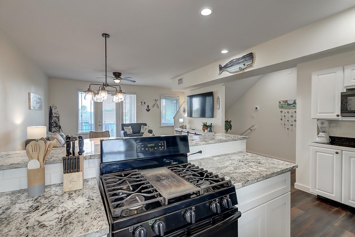 Your fully equipped kitchen features granite counters and gas range, perfect for preparing meals while staying connected to your guests.