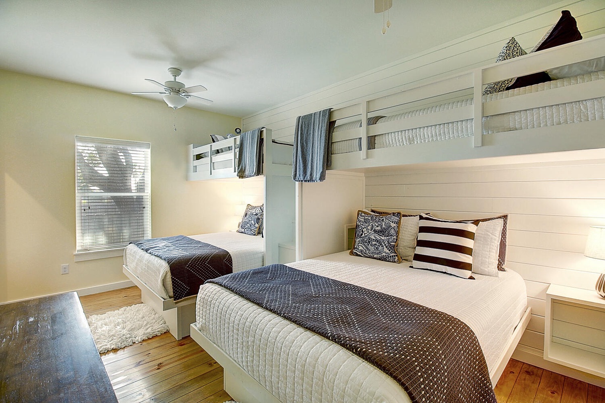 Cozy bunk room with custom-built beds, soft linens, and nautical touches—perfect for your family's beachside retreat adventure.