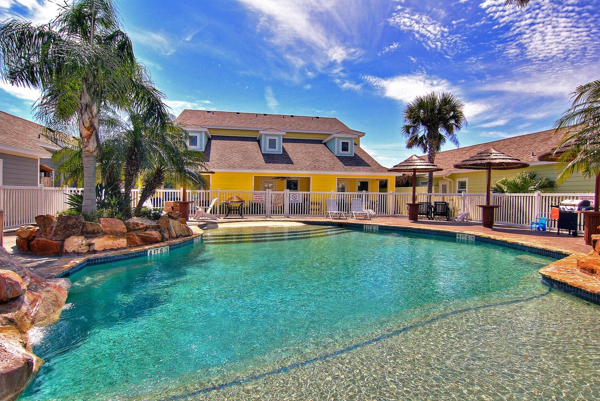 Dive into crystal-clear waters surrounded by tropical palms and colorful coastal architecture under brilliant blue skies.