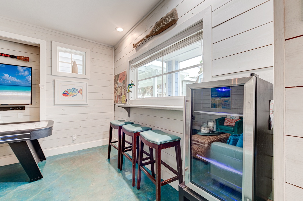Your beach-themed kitchen bar awaits with coastal charm, modern appliances, and cheerful stools where you'll enjoy morning coffee.