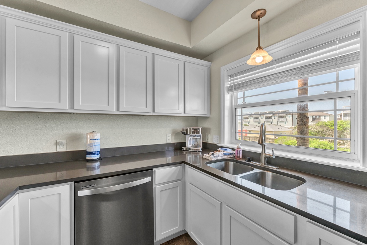 Your fully-equipped kitchen features sleek granite counters and crisp white cabinets, perfect for preparing meals while enjoying views.