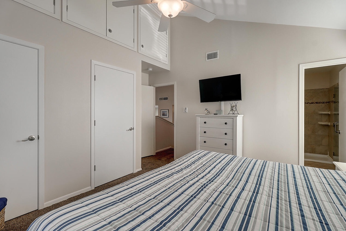 Your peaceful bedroom features a comfy bed with crisp linens, wall-mounted TV for evening relaxation, and an ensuite bathroom steps away.