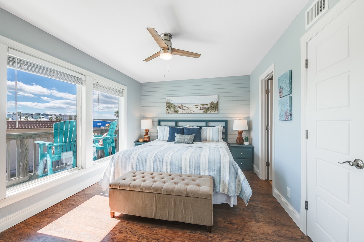 Wake up in your coastal retreat with soothing blue walls and ocean views streaming through bright windows.