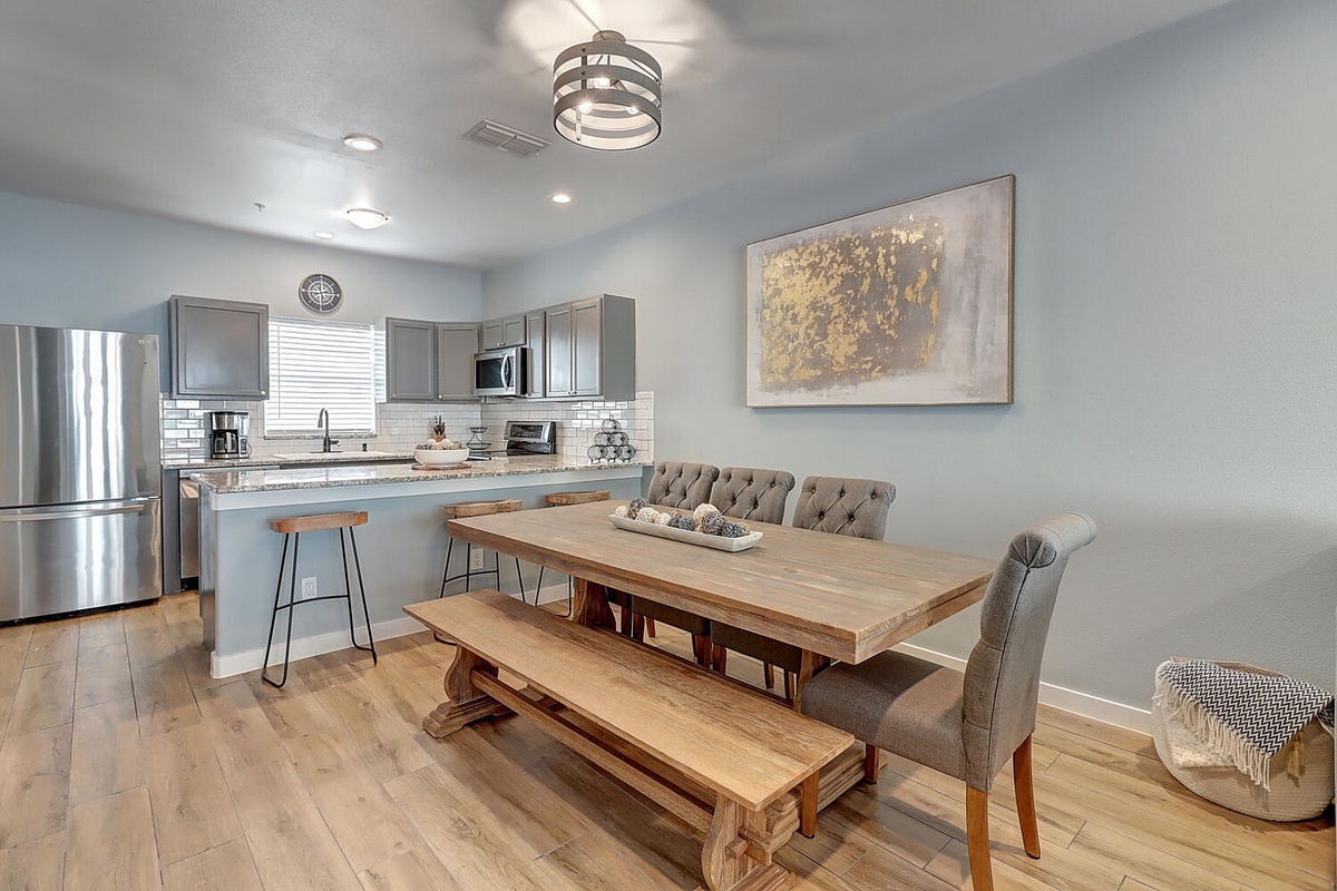 Gather around this inviting dining table where your group can share meals and make memories in the open kitchen space.