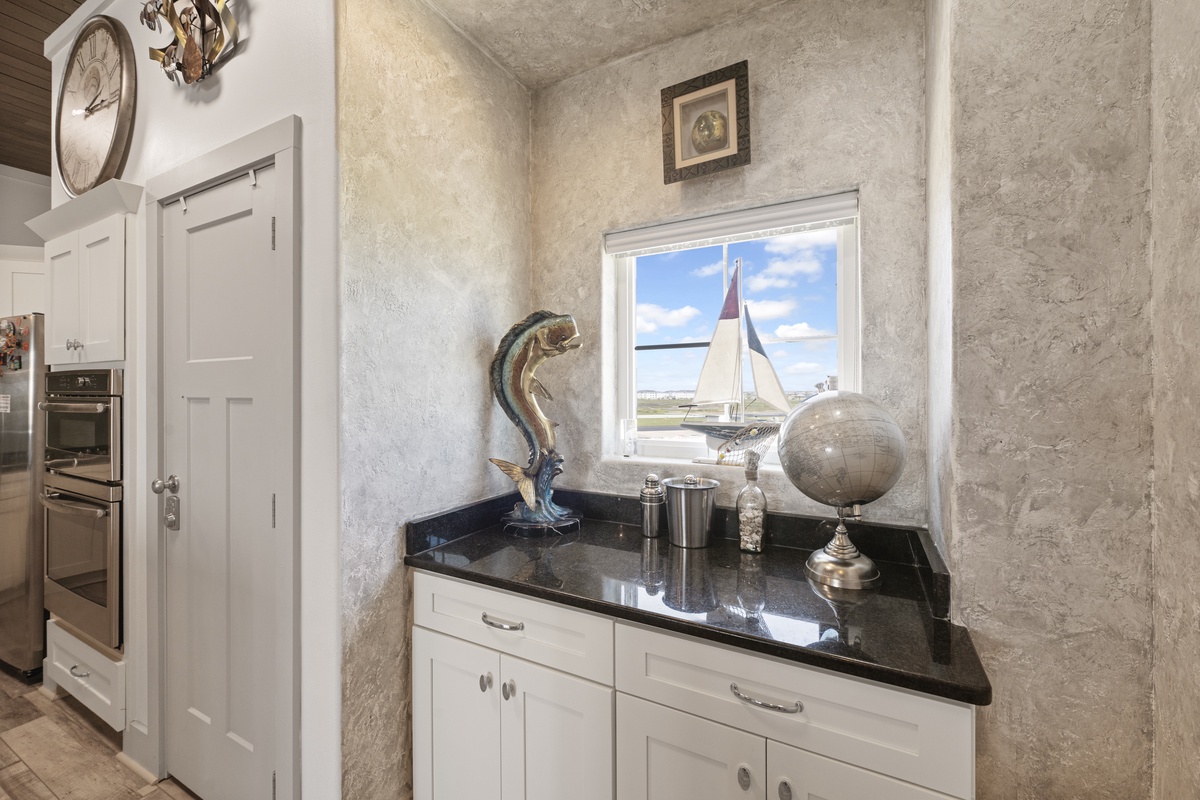 Your elegant kitchen butler's pantry features sleek black granite counters and nautical touches that inspire culinary adventures.