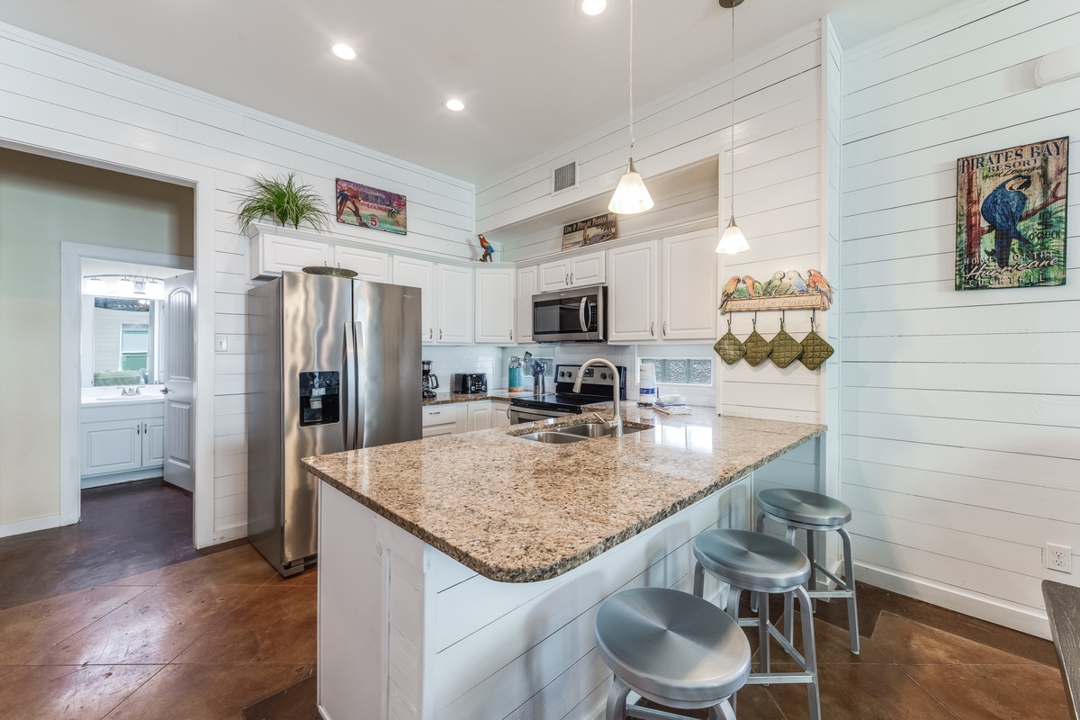 Gather around your spacious kitchen island with granite counters and gleaming stainless appliances, perfect for meal prep and morning coffee conversations.