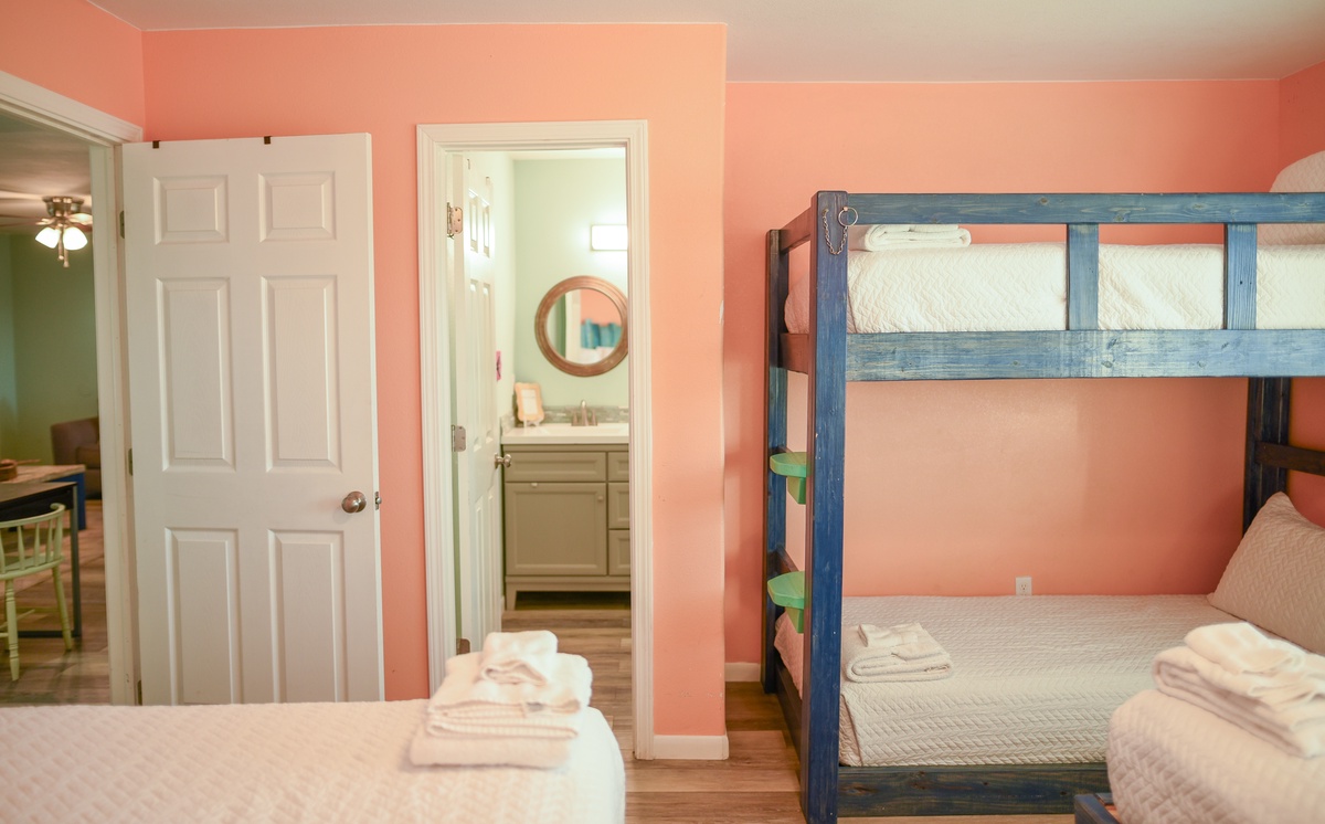 Your cheerful coral bedroom features both a cozy single bed and sturdy bunk bed, perfect for families or friends traveling together.