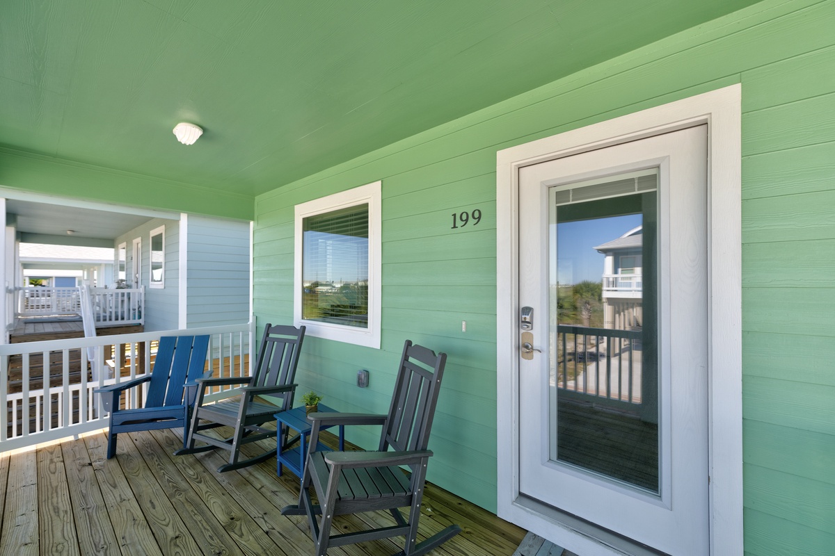 Your private covered porch invites you to relax in comfortable rocking chairs, perfect for morning coffee or watching coastal sunsets unfold.