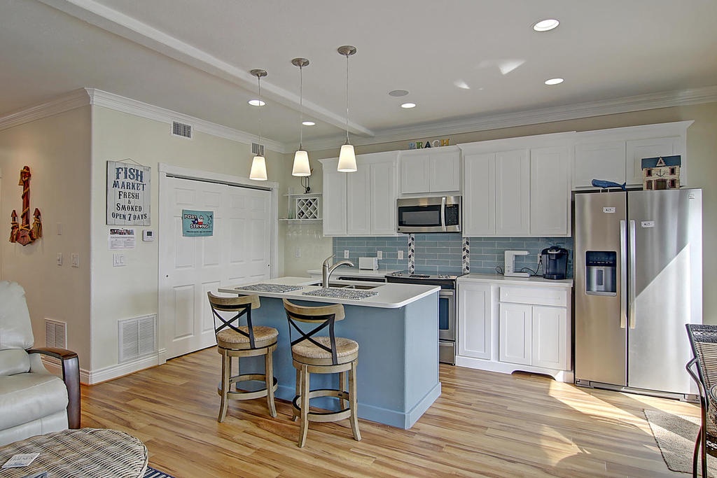 You'll love preparing meals in this bright coastal kitchen with granite counters, stainless appliances, and charming island seating.