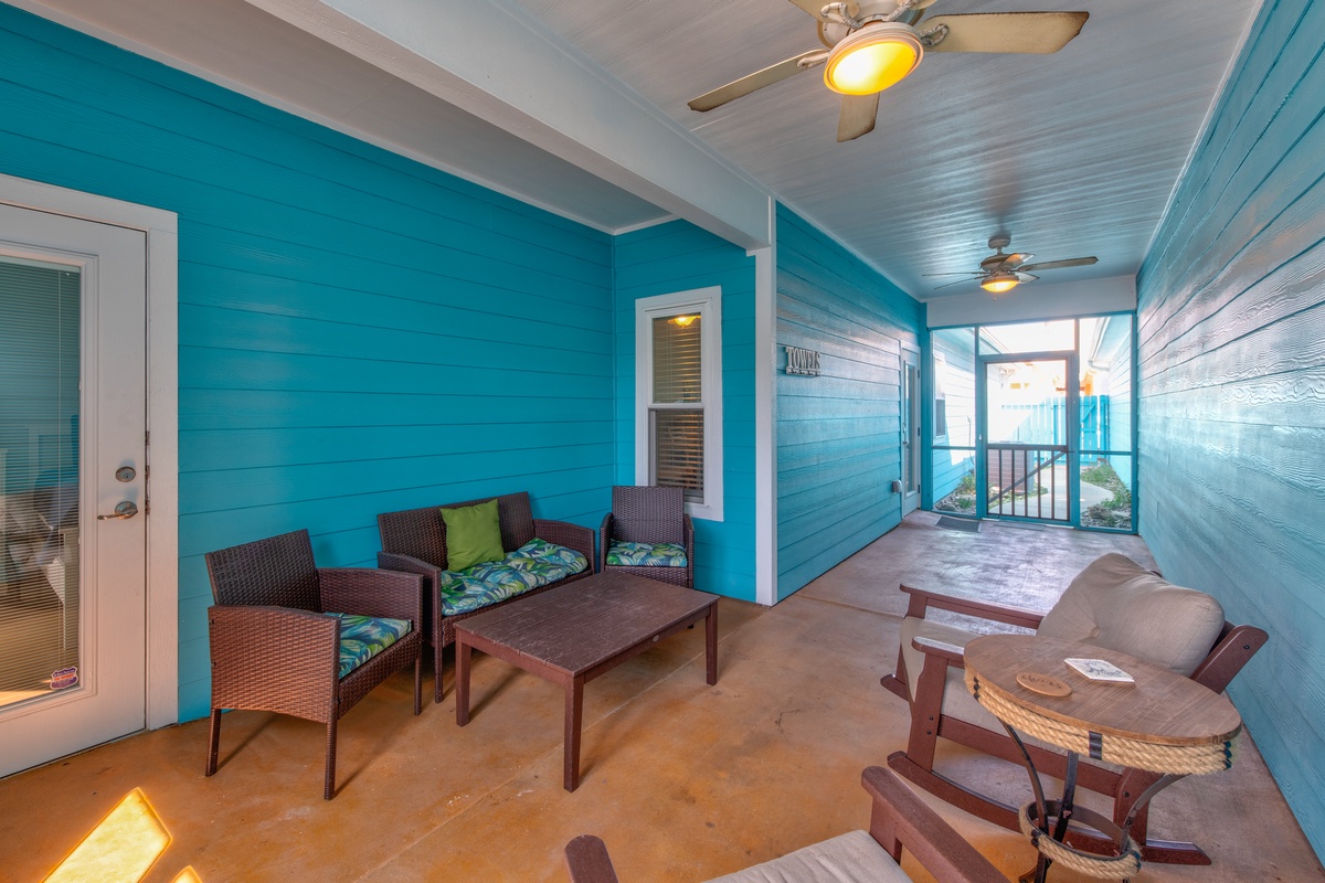 Relax on your covered patio with tropical wicker seating and dining space, perfect for morning coffee or evening conversations.