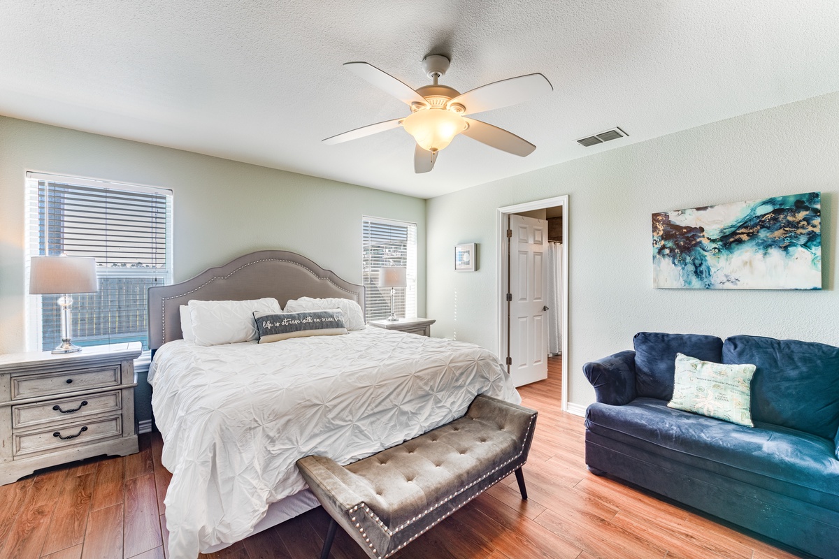 Unwind in your elegant bedroom with plush bedding, cozy seating, and warm hardwood floors beneath your feet.