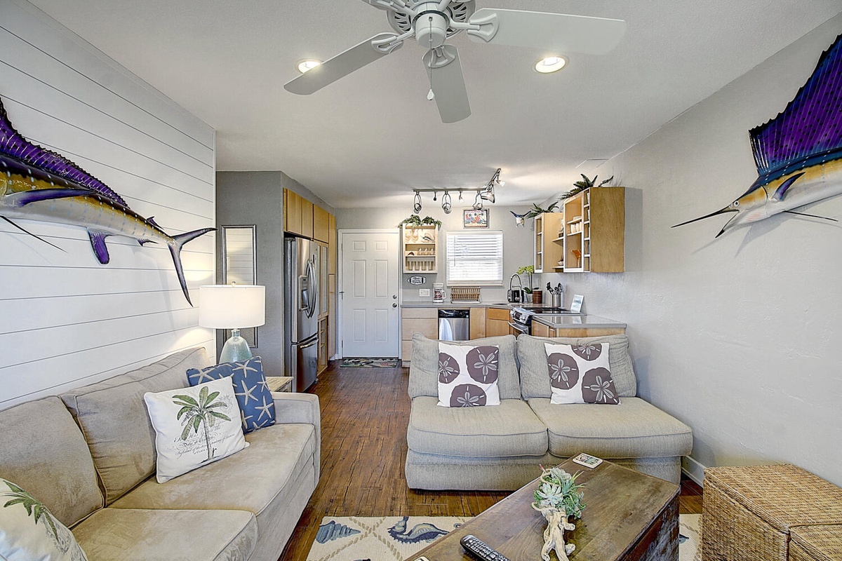 Relax in your coastal-inspired retreat featuring nautical artwork, comfortable seating, and a fully equipped kitchen perfect for preparing your favorite meals.