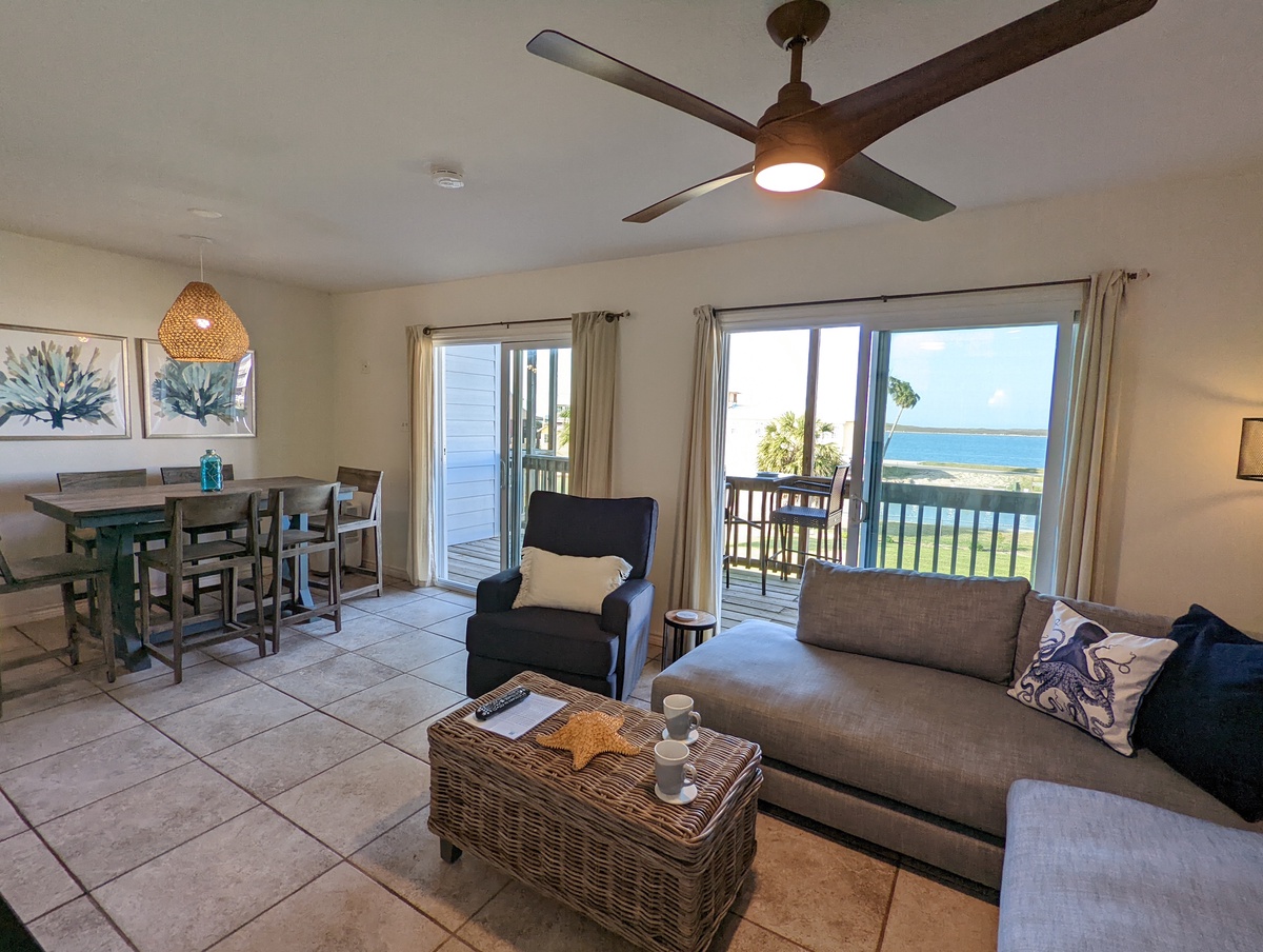 Relax in your coastal living space with ocean views, comfortable seating, and a ceiling fan keeping you cool while you enjoy the sea breeze.