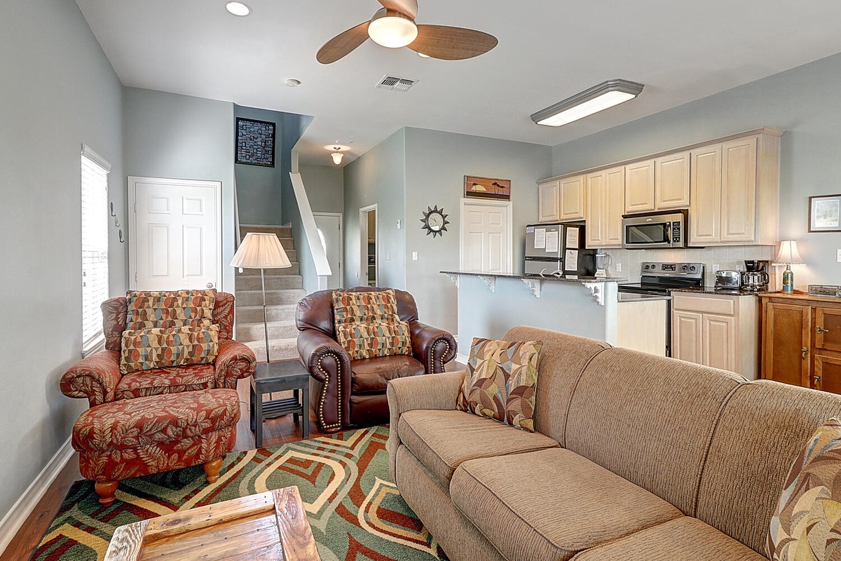 Relax in your open-concept living space where comfortable seating flows seamlessly into a fully-equipped kitchen, perfect for memorable family gatherings.