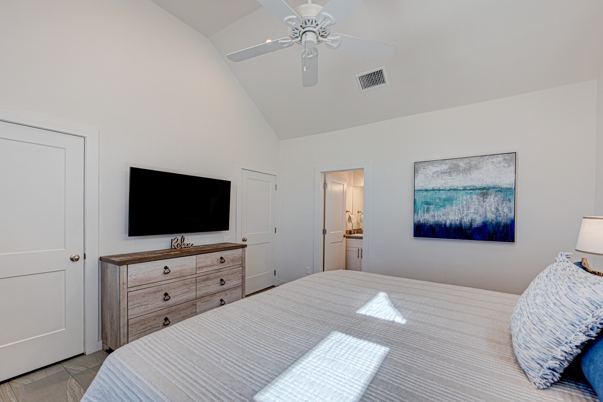 Unwind in your peaceful bedroom with modern amenities, soft linens, and calming ocean-inspired art creating the perfect retreat.