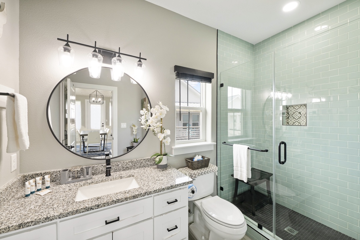 Refresh in your stylish bathroom featuring modern vanity, rainfall shower, and calming mint tile that creates a spa-like retreat.