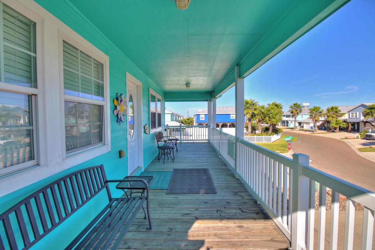 Your bright turquoise balcony offers coastal charm with outdoor seating where you can sip morning coffee while watching the neighborhood come to life.