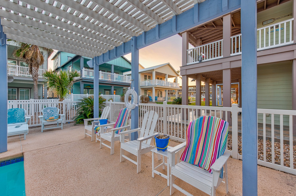 Relax on your private covered deck with colorful striped loungers, watching the peaceful neighborhood come alive around you.