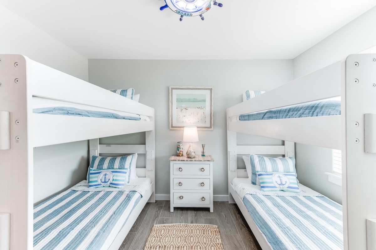 Your kids will love these cozy white bunk beds with cheerful blue striped linens and nautical touches.