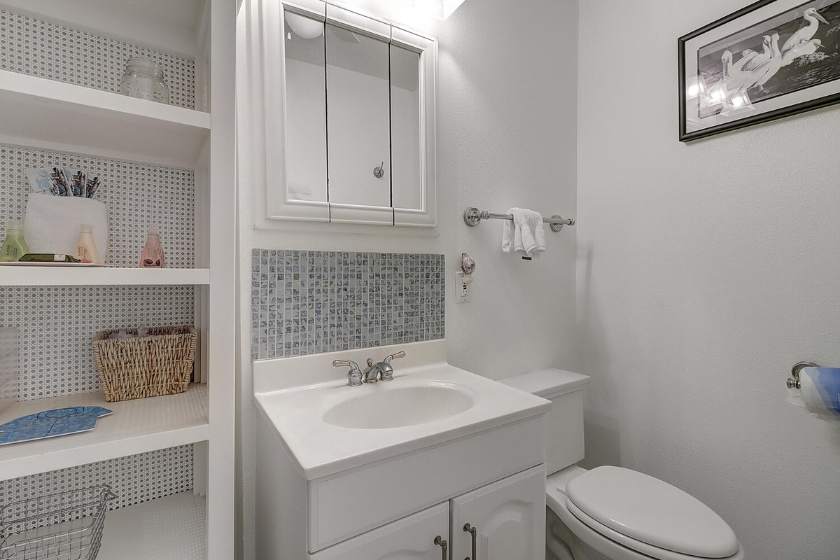Your private bathroom features a mosaic-tiled vanity, built-in storage shelves, and everything you need for a refreshing start to your day.