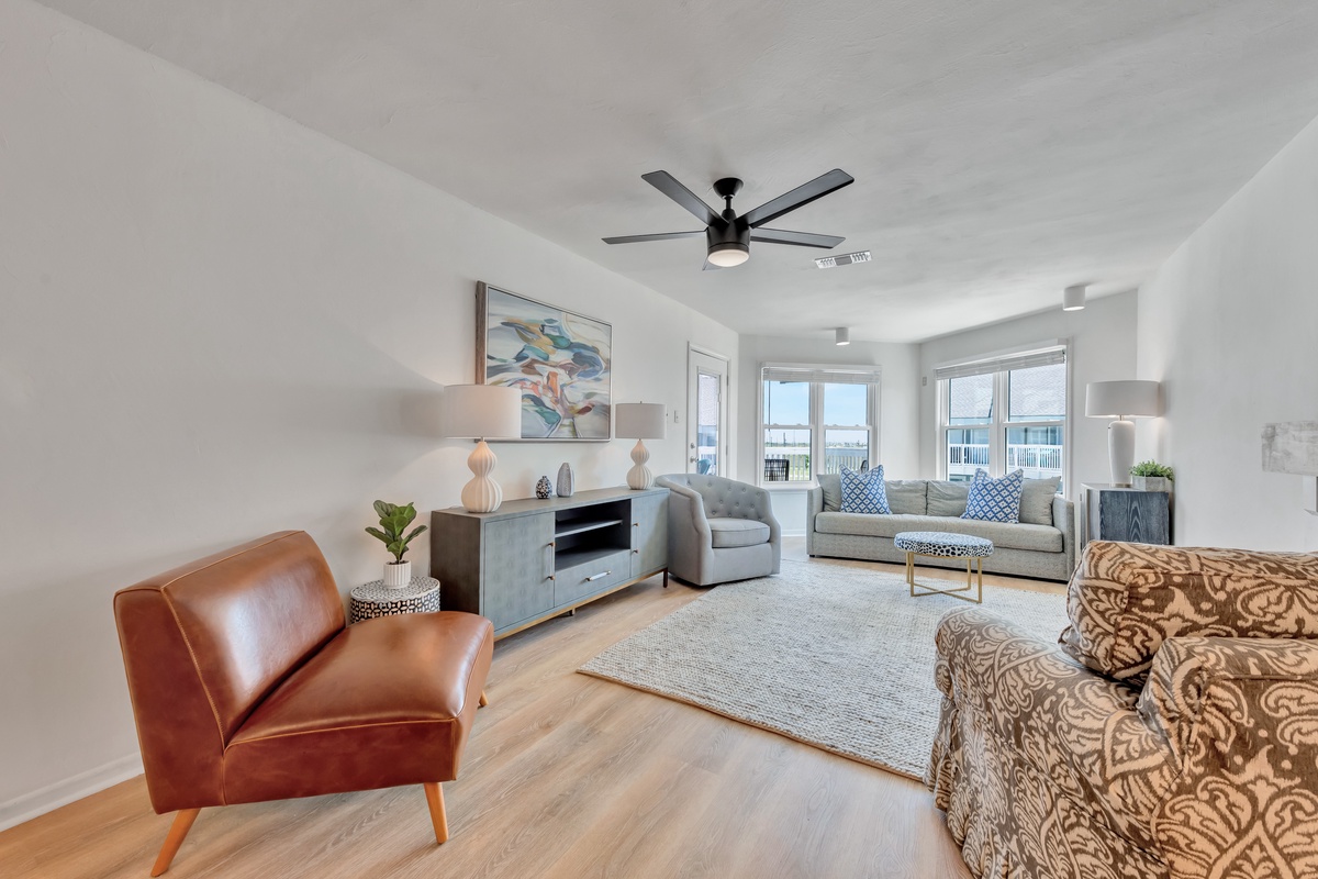 Relax in your spacious living room with comfortable seating, modern decor, and natural light streaming through large windows.