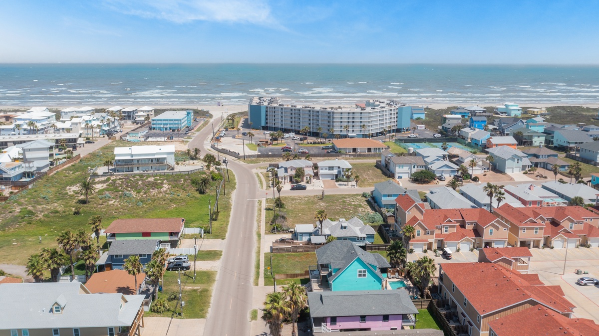 Aerial view of coastal community with beachfront access and nearby amenities.