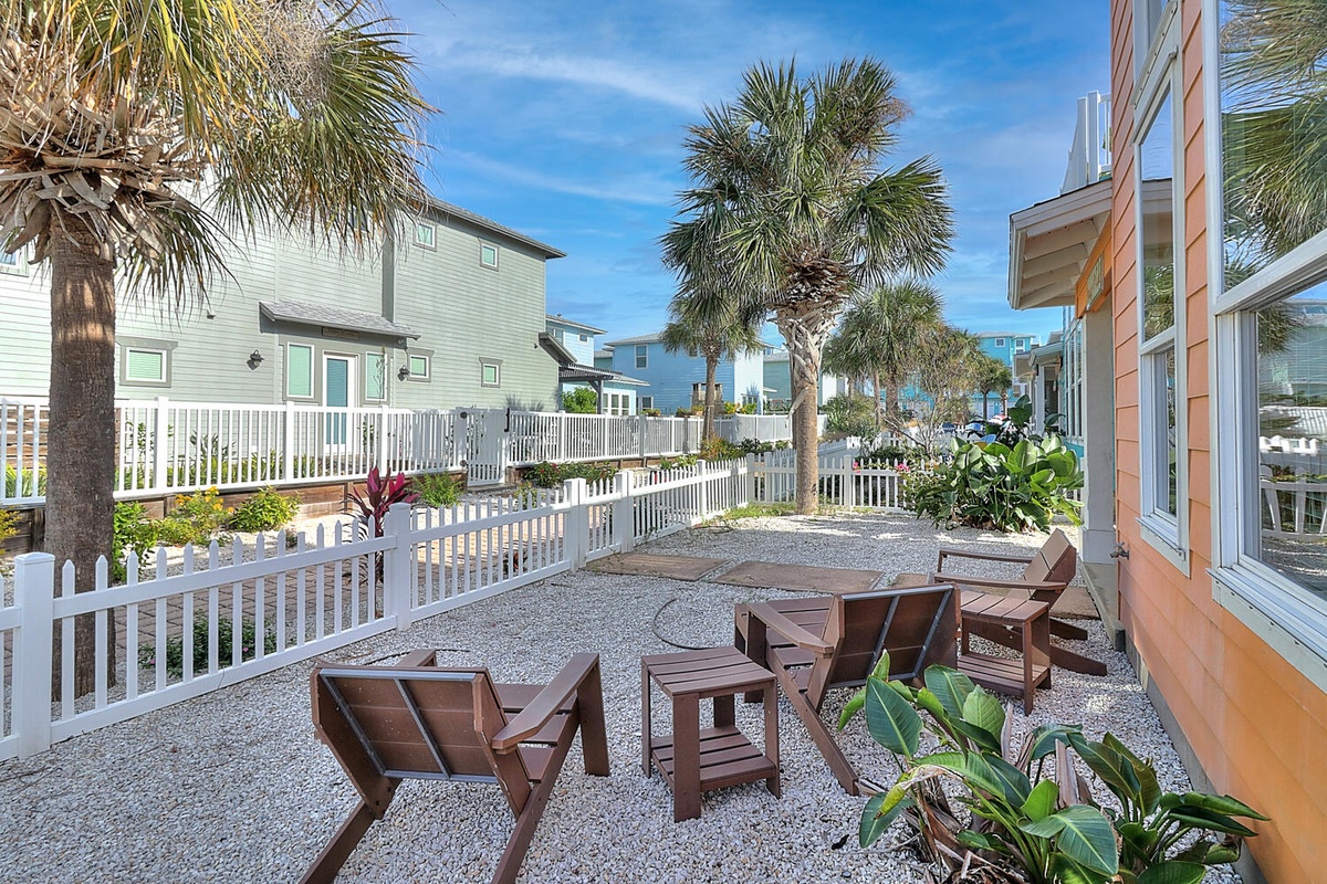 Relax in your private outdoor space with comfortable seating surrounded by tropical palms and colorful plants.