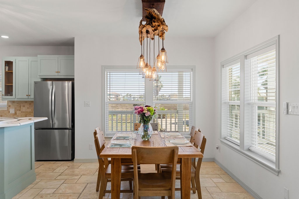 Gather around your elegant dining table, where natural light streams through windows and warm pendant lights create the perfect atmosphere for memorable meals.