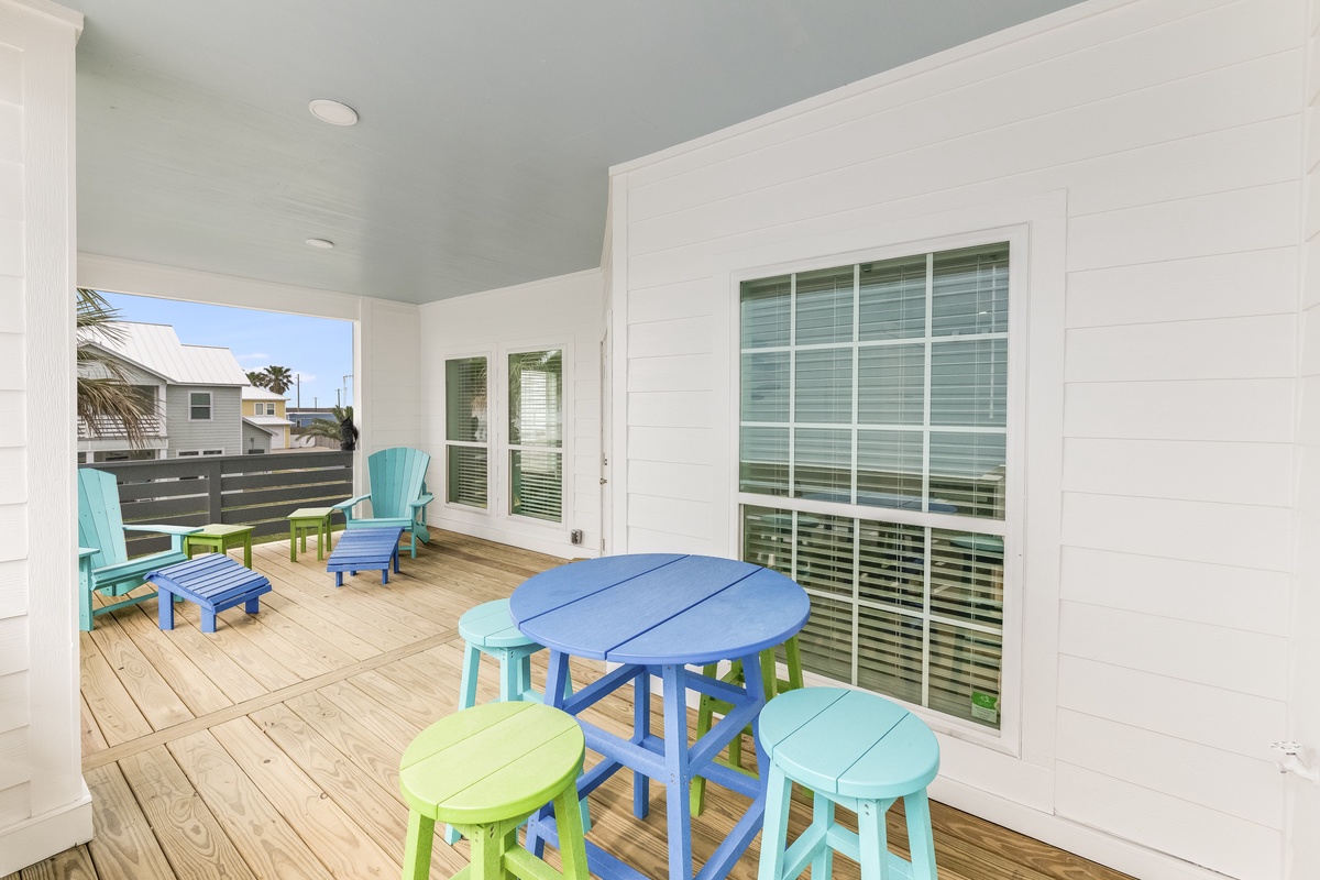 Relax on your private covered terrace with colorful coastal seating and dining table, perfect for morning coffee or evening cocktails.