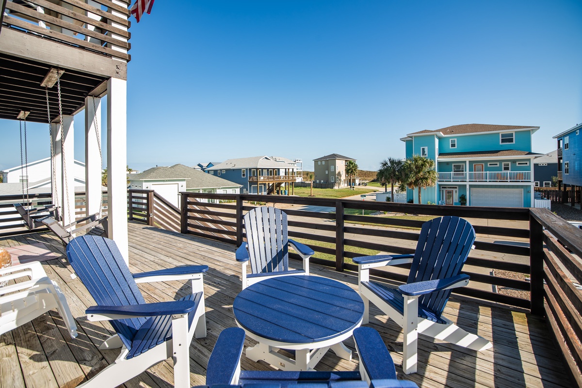 Your spacious deck features bright blue Adirondack chairs where you can relax and soak up the sunshine while taking in coastal neighborhood views.