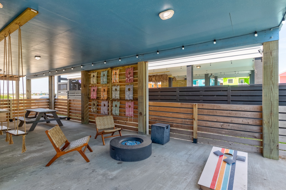 Your private covered patio features a fire pit, cozy seating, and fun games—perfect for relaxing evenings under string lights by the coast.