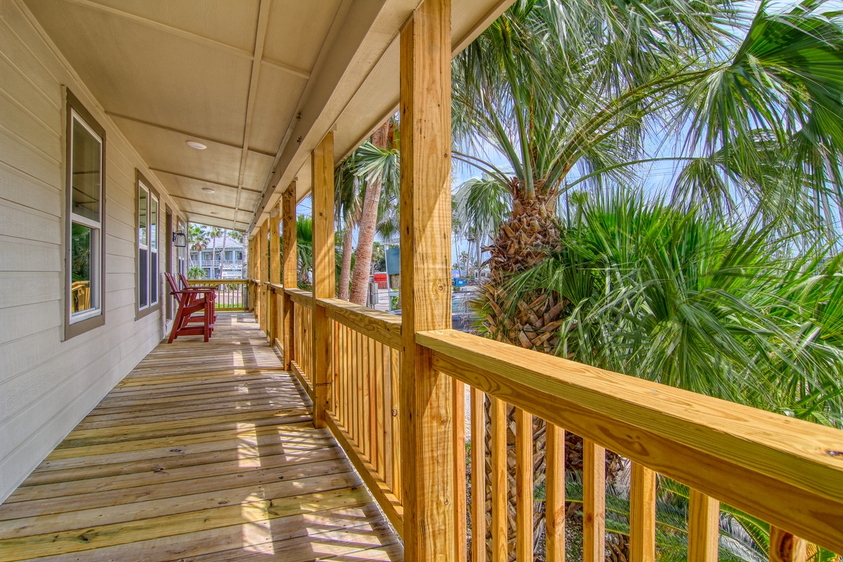Step onto your private wooden balcony where tropical palms sway just beyond the railing, creating your perfect island retreat.