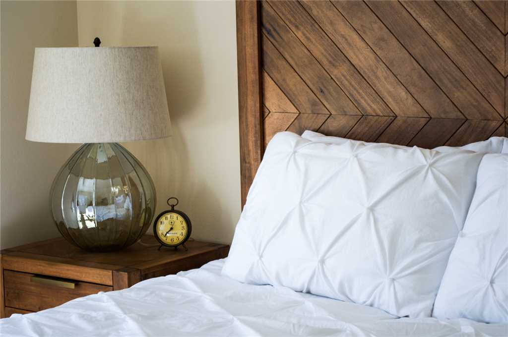 Second floor primary bedroom with flat screen TV and view of the woods