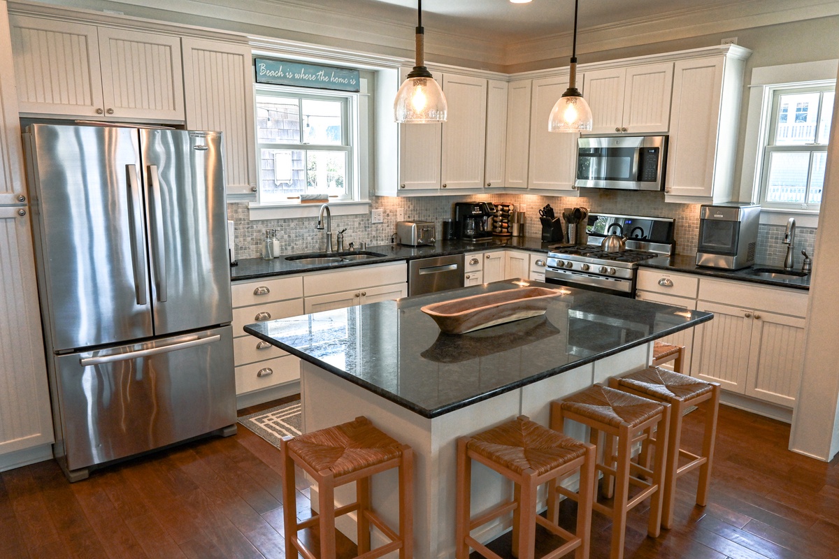 Spacious kitchen is well furnished with granite countertops, large island, five bar stools, double oven