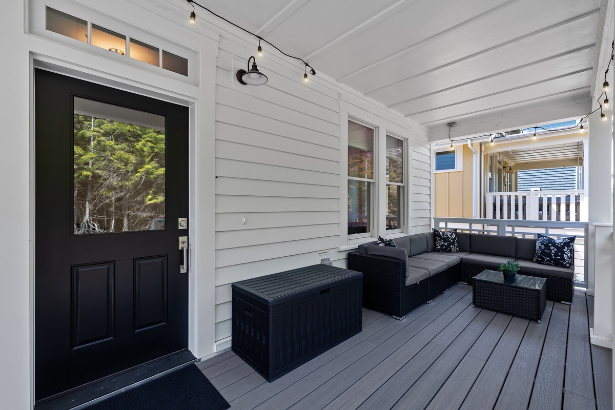 Covered front porch with outdoor sofa and gas grill