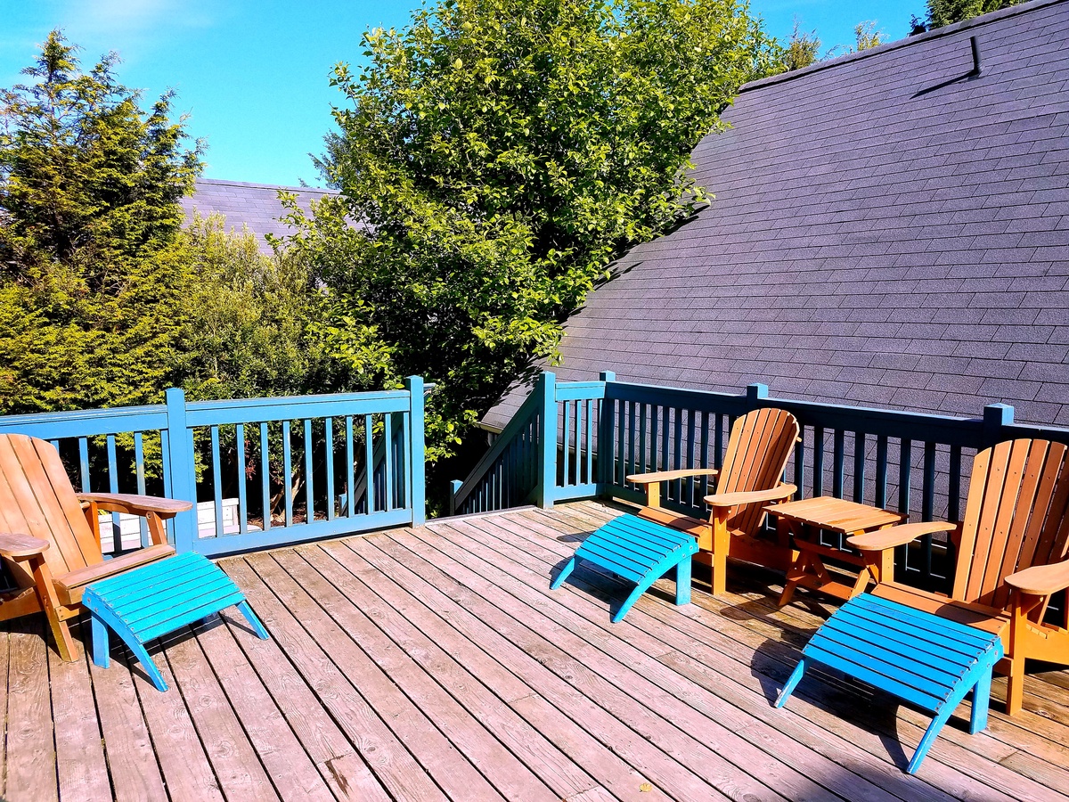 Private sunny backyard deck with lounge chairs, gas BBQ and lovely forest views