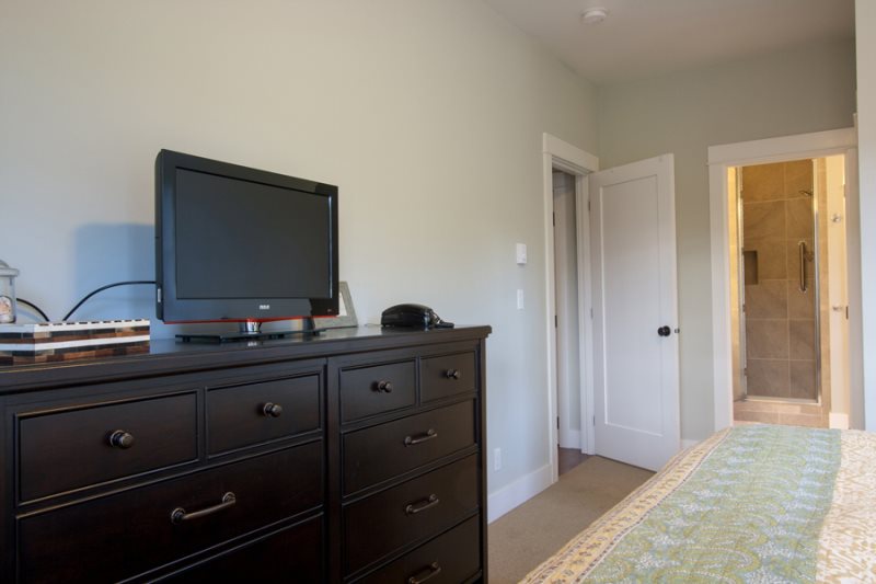 Main floor - primary bedroom with a king-size bed and adjoining spa-like bathroom