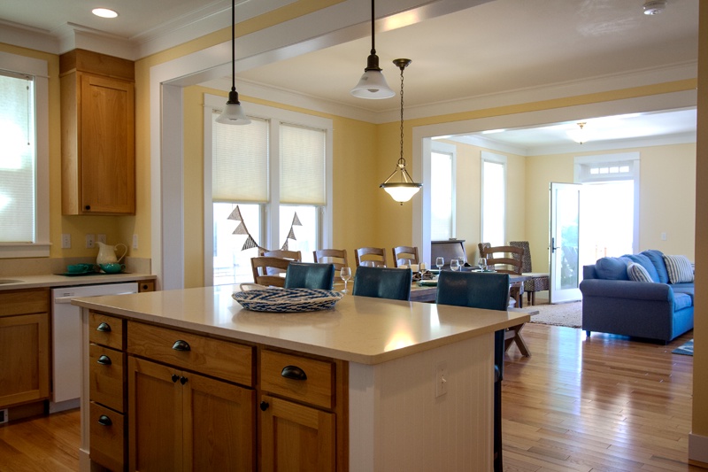 Kitchen boasts a convenient center island with three high-backed leather bar stools