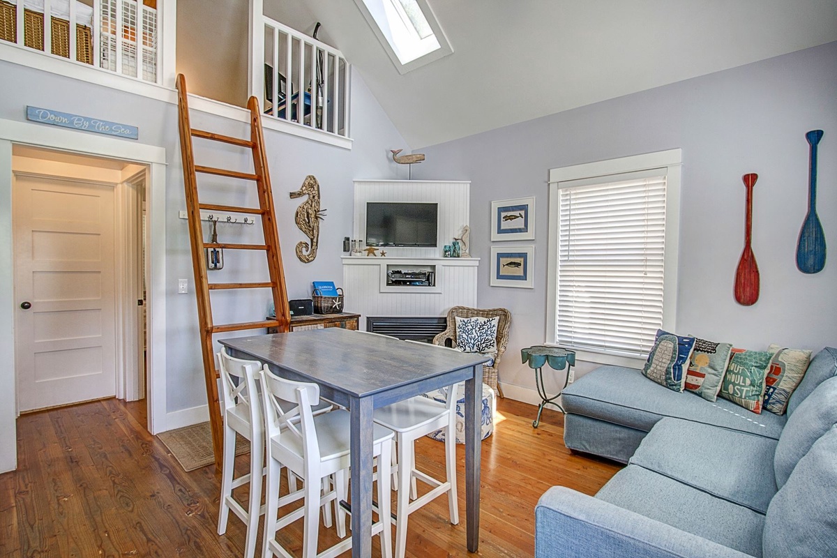 Living room, dining table, and ladder to loft