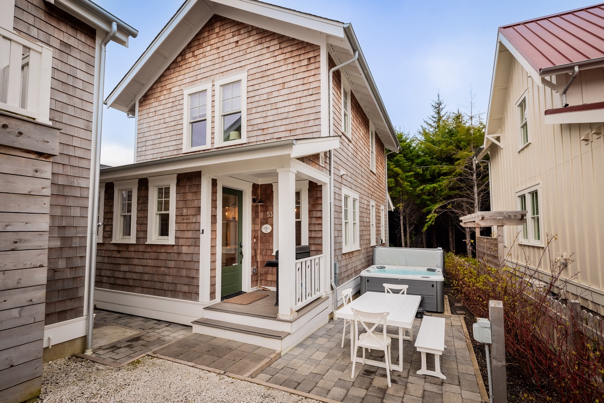 Back exterior with hot tub and outdoor dining