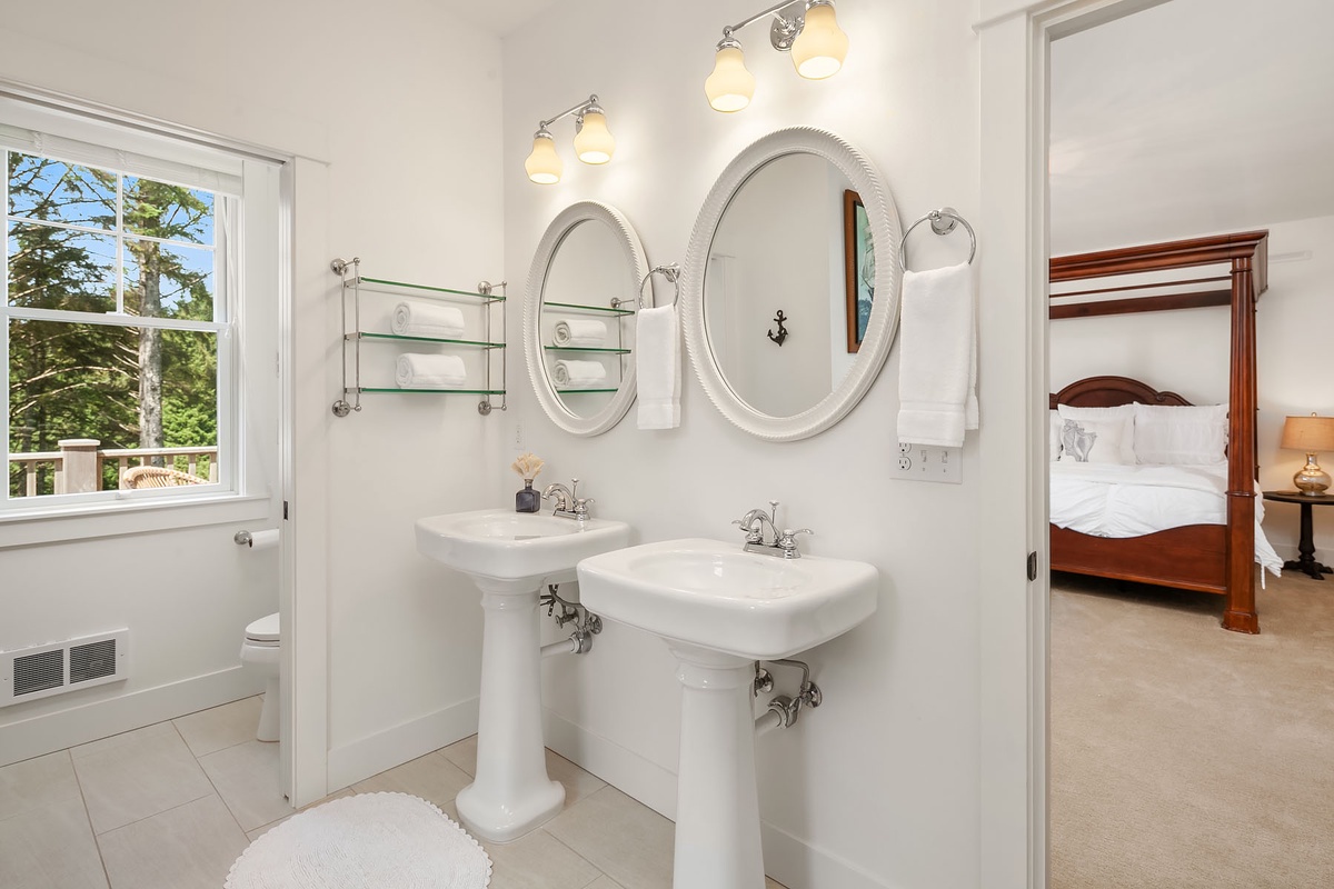 Primary bath with 2 sinks, double ended pedestal tub and tiled shower