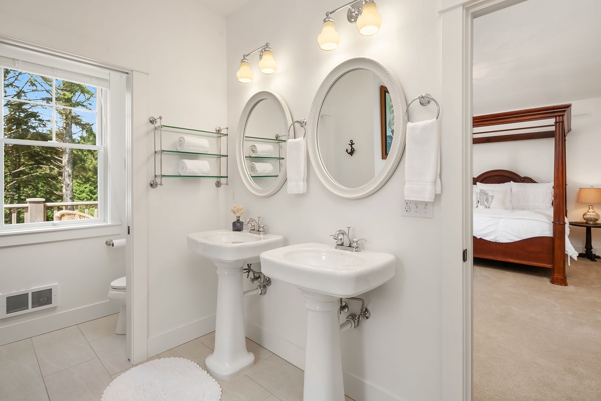 Primary bath with 2 sinks, double ended pedestal tub and tiled shower