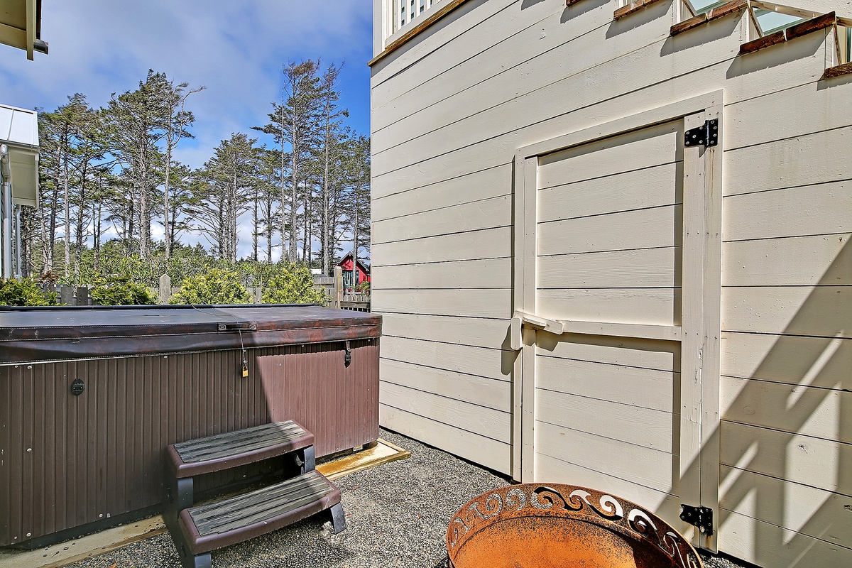 Outdoor fire pit and hot tub between home and Carriage House