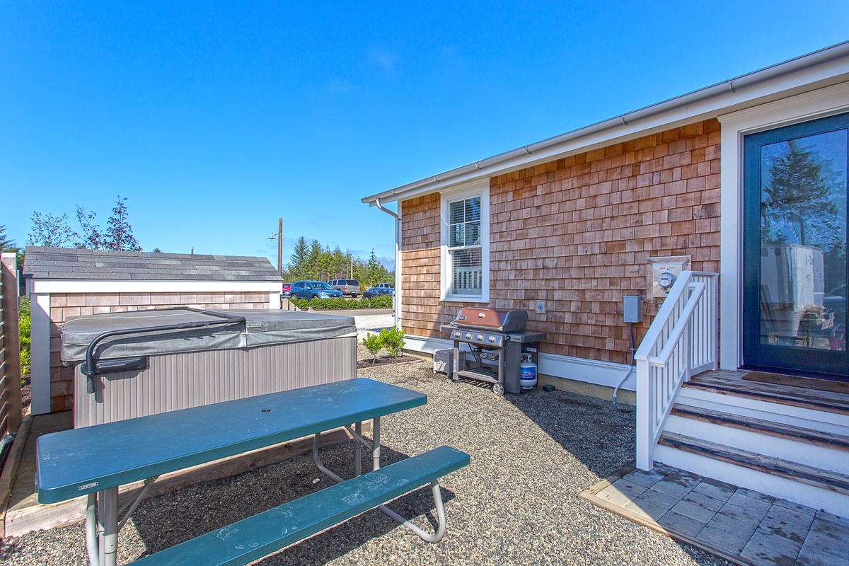 Private patio with hot tub, picnic table, and grill