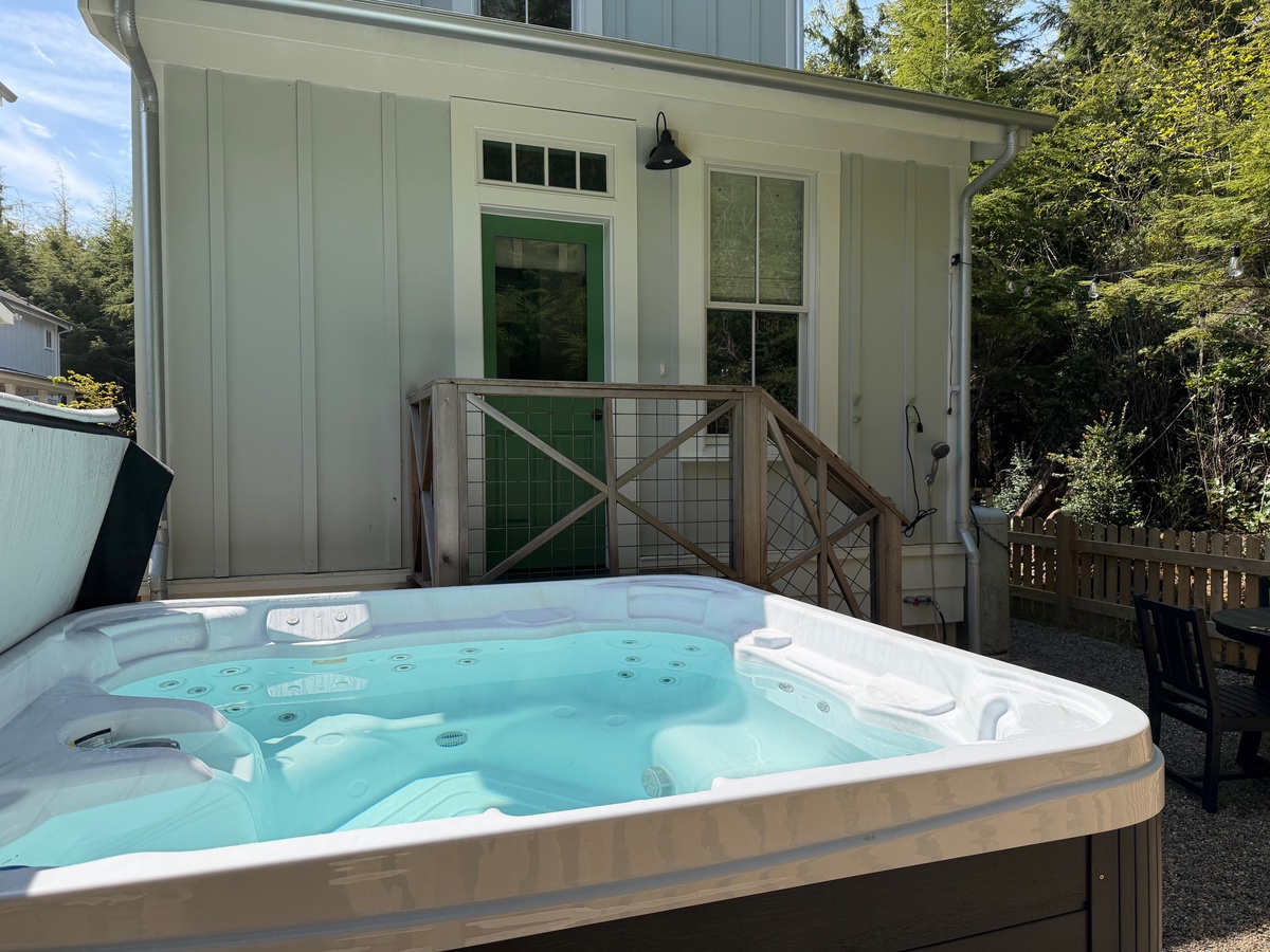 Soak away your cares in this spacious hot tub, nestled in the private backyard surrounded by lush greenery and peaceful natural beauty.